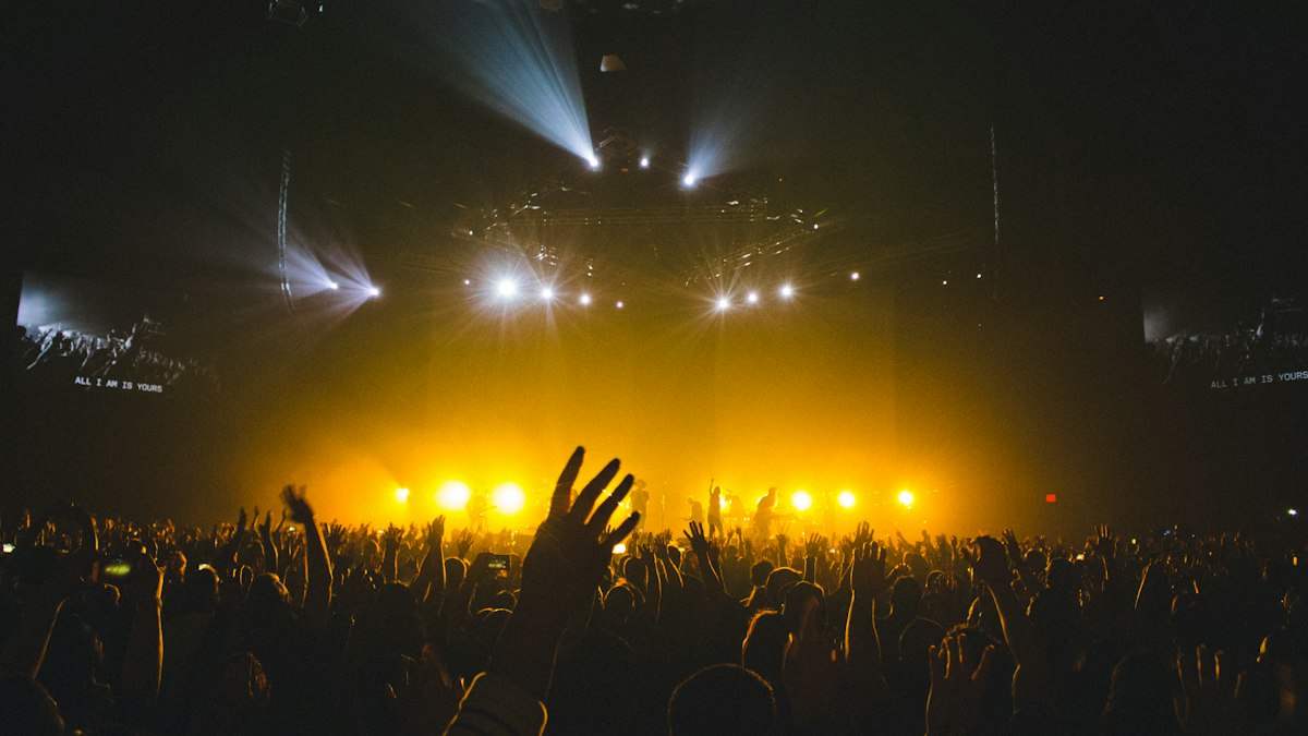 Palco de show vazio com luzes acesas, representando evento cancelado ou adiado