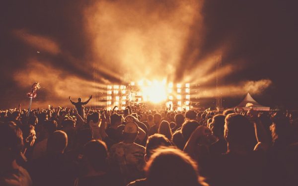 Público de braços erguidos em show noturno, ilustrando a divulgação de evento e a venda antecipada de ingresso