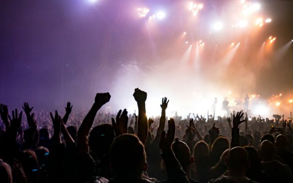 Público de mãos levantadas em show noturno em casa de show, ilustrando o direito à meia-entrada em Fortaleza